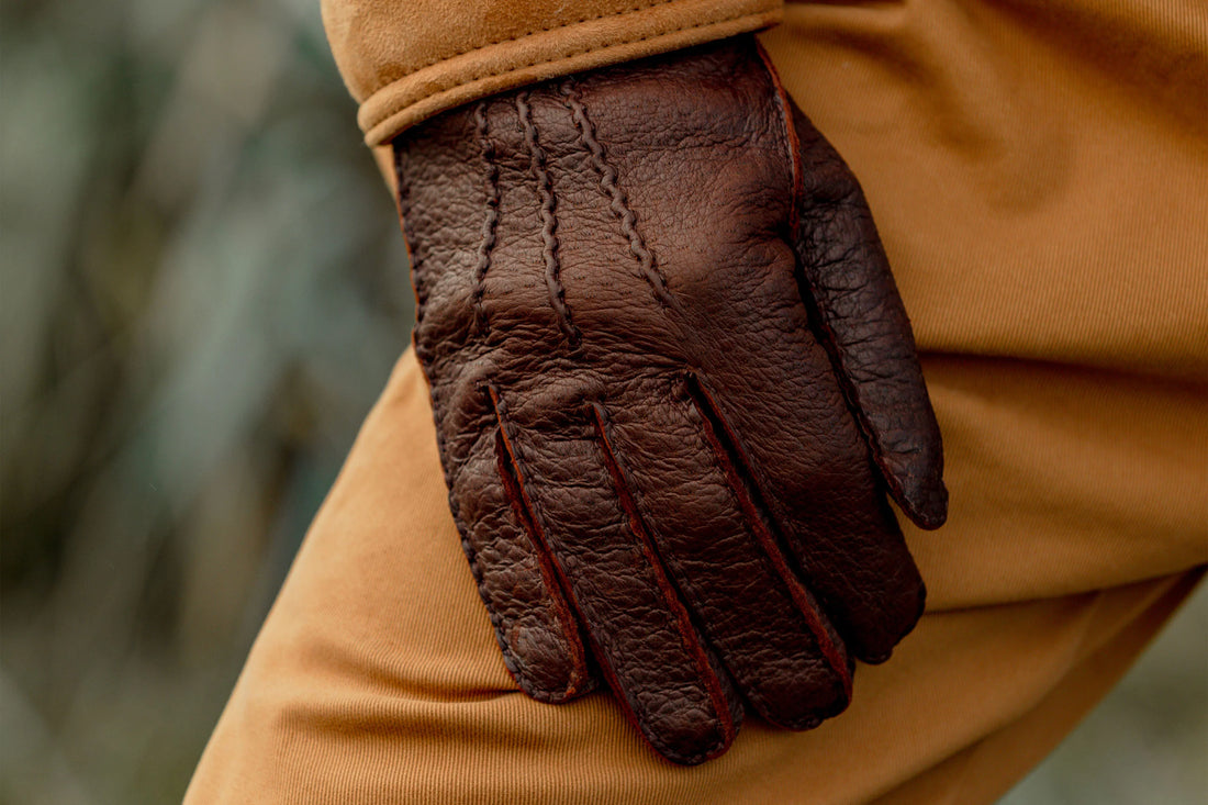 Close-up of a person wearing a brown leather glove.