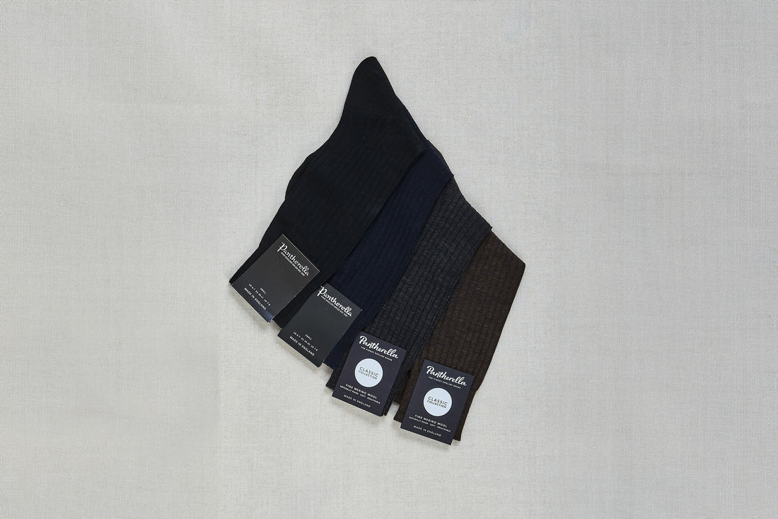 Three pairs of folded dress socks with labels displayed on a neutral background.