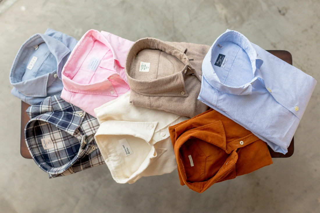 A collection of neatly folded shirts in various colors and patterns displayed on a table.