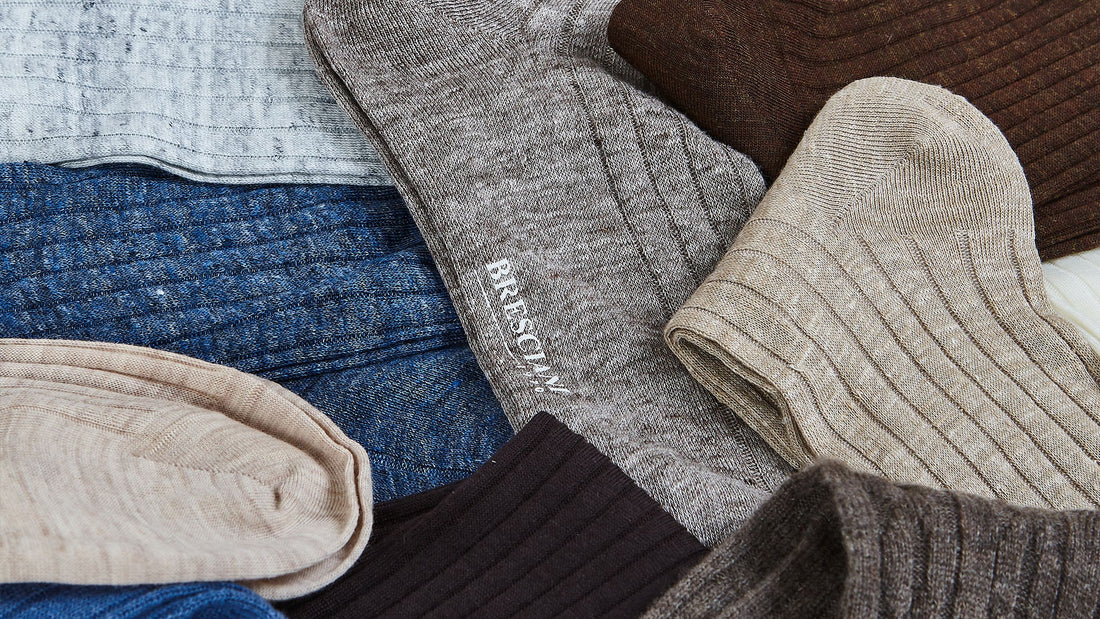 Various textured fabrics and knitwear with visible branding displayed in an overlapping arrangement.