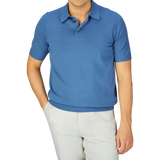 Man wearing an Alan Paine Airforce Blue Knitted Cotton Polo Shirt and white pants.