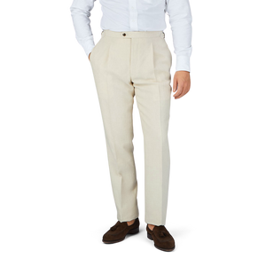 A man in a white shirt and Baltzar Sartorial Light Beige Pure Linen Pleated Trousers.