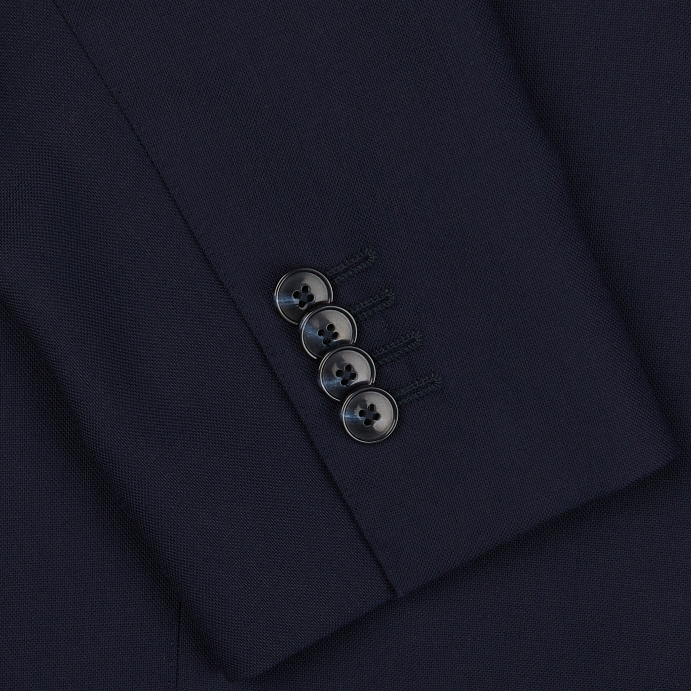 Close-up of a Baltzar Sartorial Navy Blue Super 100s Wool DB Suit Jacket sleeve with four buttons detailed in a vertical line.