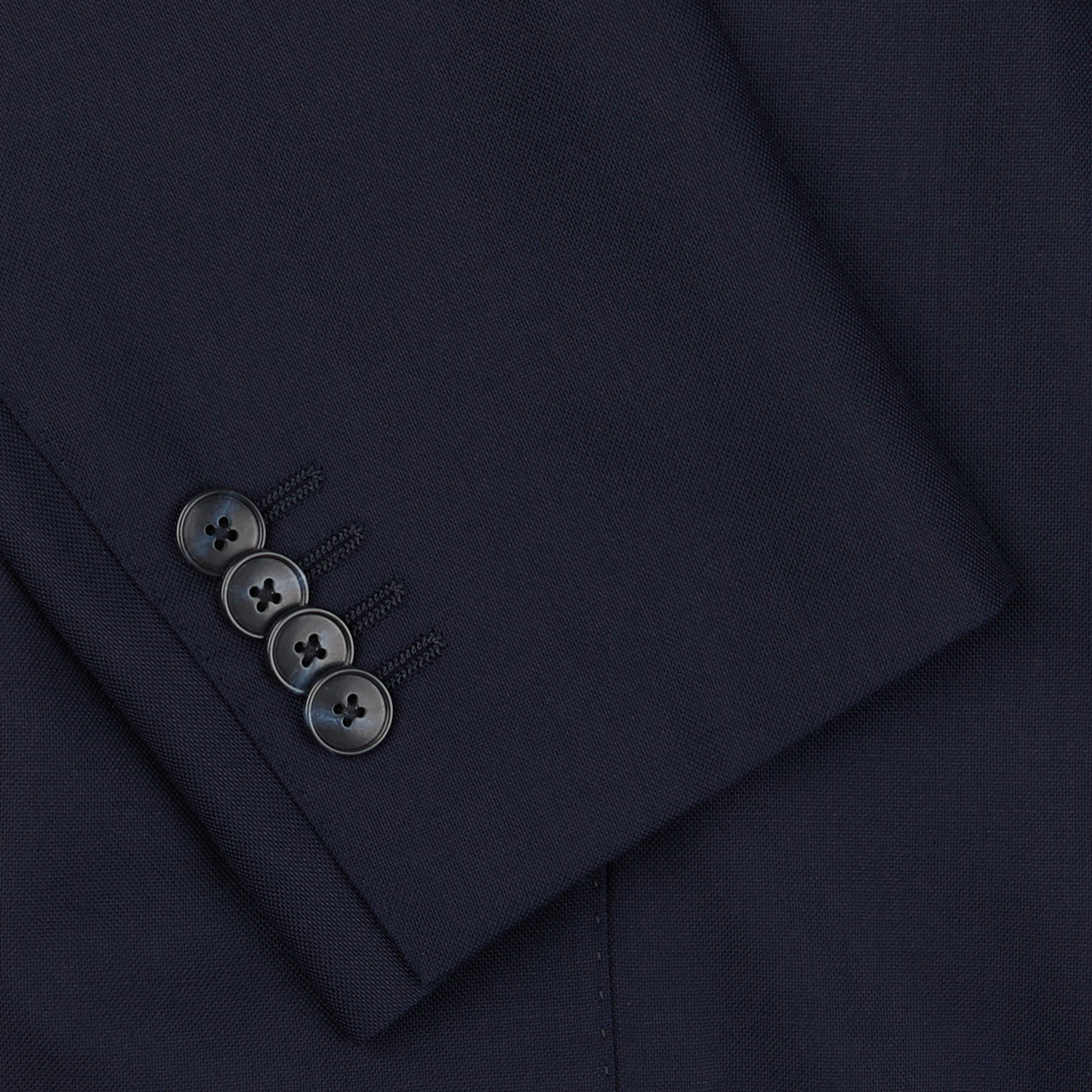 Close-up of a Baltzar Sartorial navy Super 100's wool suit jacket sleeve, featuring a row of four dark buttons.