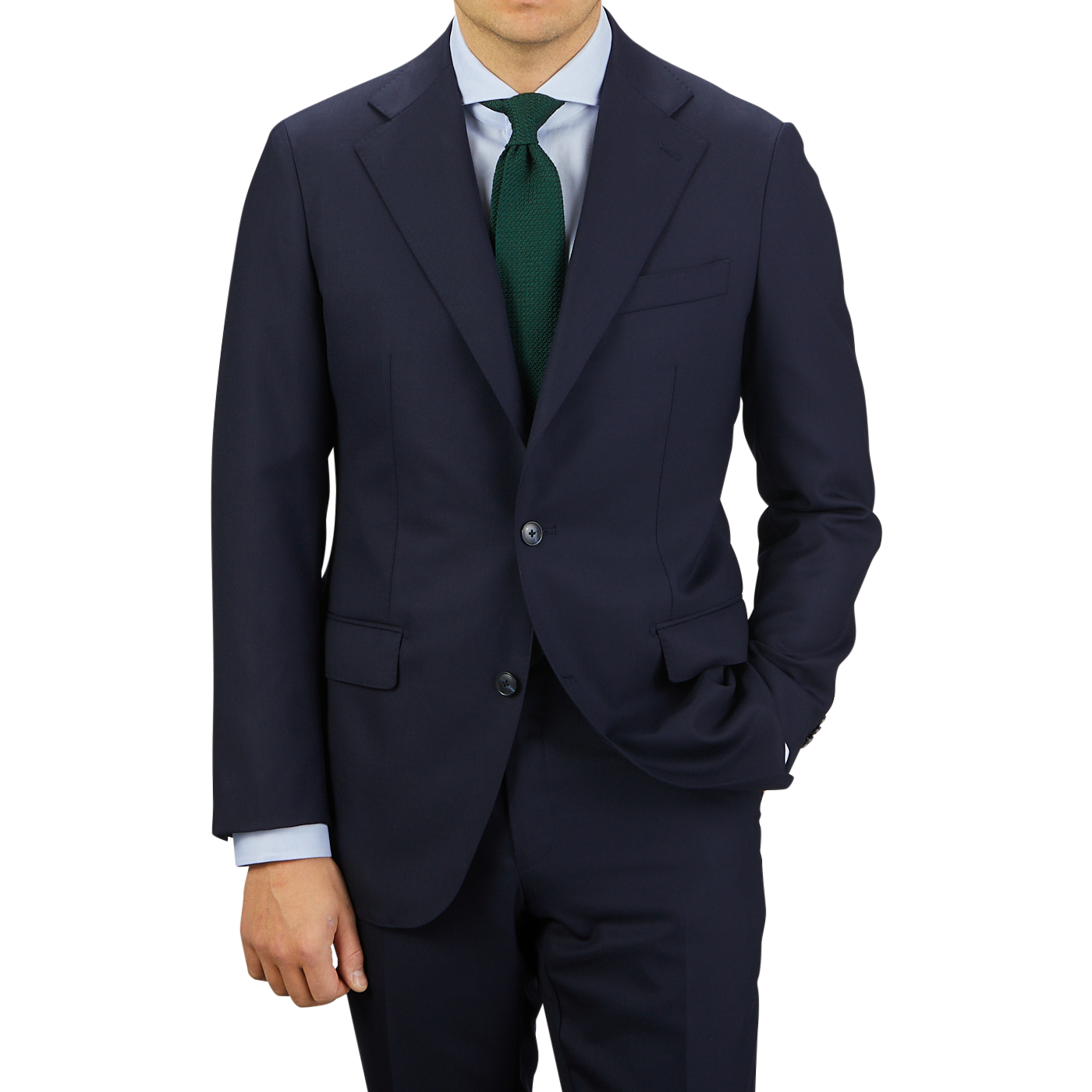 Man in a Baltzar Sartorial Navy Super 100's Wool Suit Jacket with a teal tie standing against a grey background.