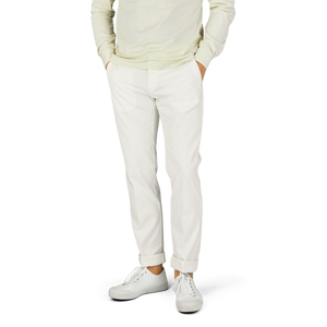 A man wearing Berwich cream white cotton stretch chinos and a green sweater.