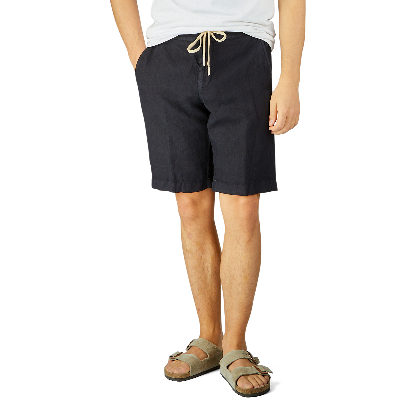 Man wearing Berwich navy blue washed linen drawstring shorts and gray sandals stands against a light background, focusing on his lower torso and legs.