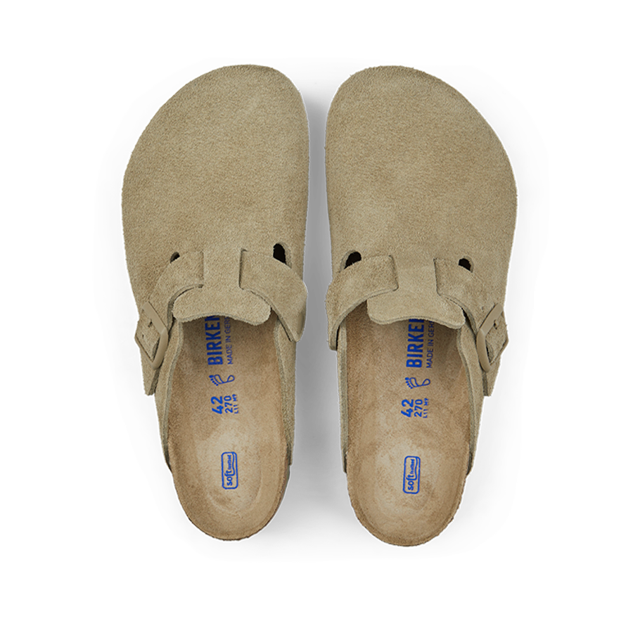 A pair of Faded Khaki Suede Leather Birkenstock Boston Slippers displayed against a black background.