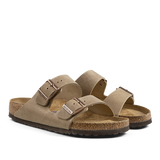 A pair of suede, open-toe Birkenstock sandals with buckle straps and cork soles.