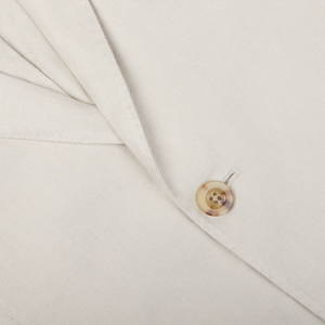 A close-up view of a Light Beige Washed Irish Linen Boglioli K Jacket with a button and stitching detail.