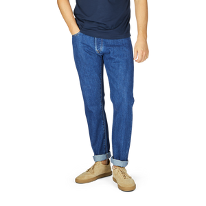 Man wearing C.O.F Studio Blue Organic Kurioki Cotton M7 6x Wash Jeans and beige shoes, cropped at chest level against a white background.