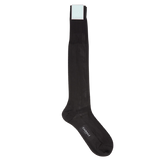 A pair of black knee length silk dress socks on a white background by Canali.