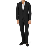 A man is posing in a Canali Black Virgin Wool Twill Suit.