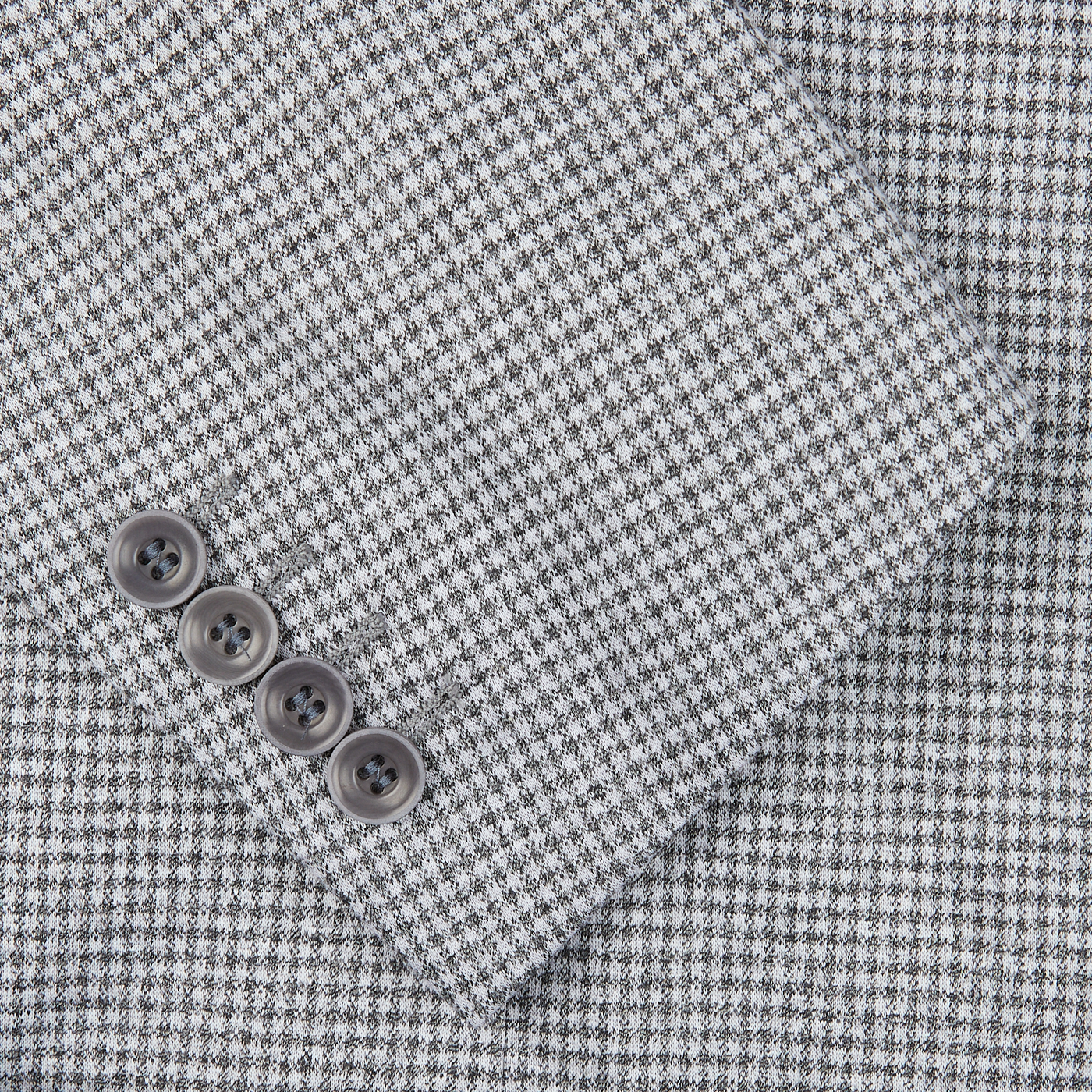 A close up of a Light Grey Houndstooth Cotton Jersey Blazer made by Canali, showcasing casual tailoring.