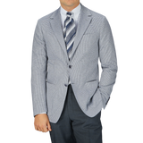 A man is posing in a Canali Light Grey Houndstooth Cotton Jersey Blazer and tie.