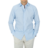 A man wearing a Canali Plain Blue Cotton Poplin Single Cuff Shirt.