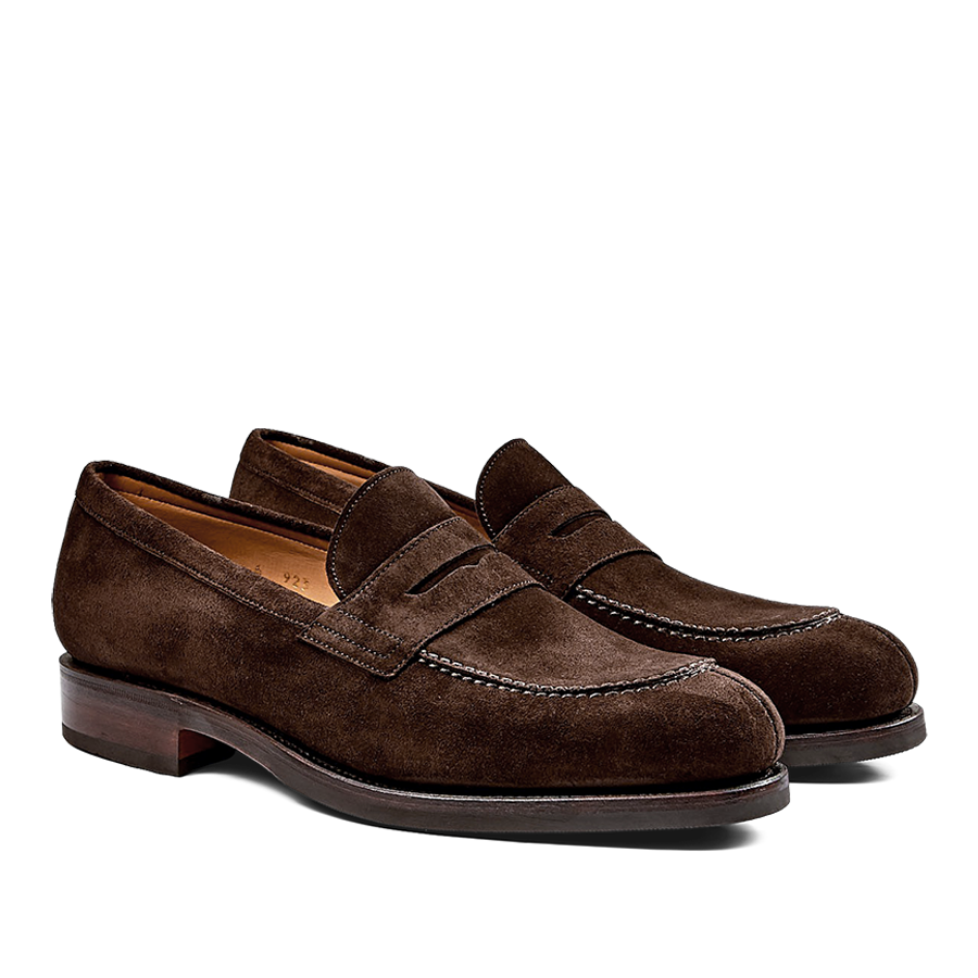 A pair of Brown Suede Forest Rubber Penny Loafers crafted by expert craftsmen against a black background.