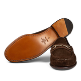 A pair of brown Carmina Chocolate Suede Leather Xim Horsebit Loafers on a transparent background.