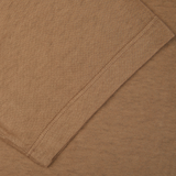 A close up image of a tan Drumohr coffee brown cotton linen polo shirt.