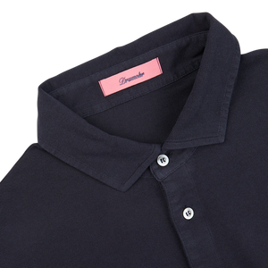 Close-up of a Navy Blue Cotton Piquet Polo Shirt with a pink Drumohr label on the collar, made in Italy.