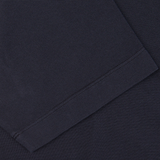 Close-up view of a Drumohr navy blue cotton piquet polo shirt with visible texture and stitching detail.