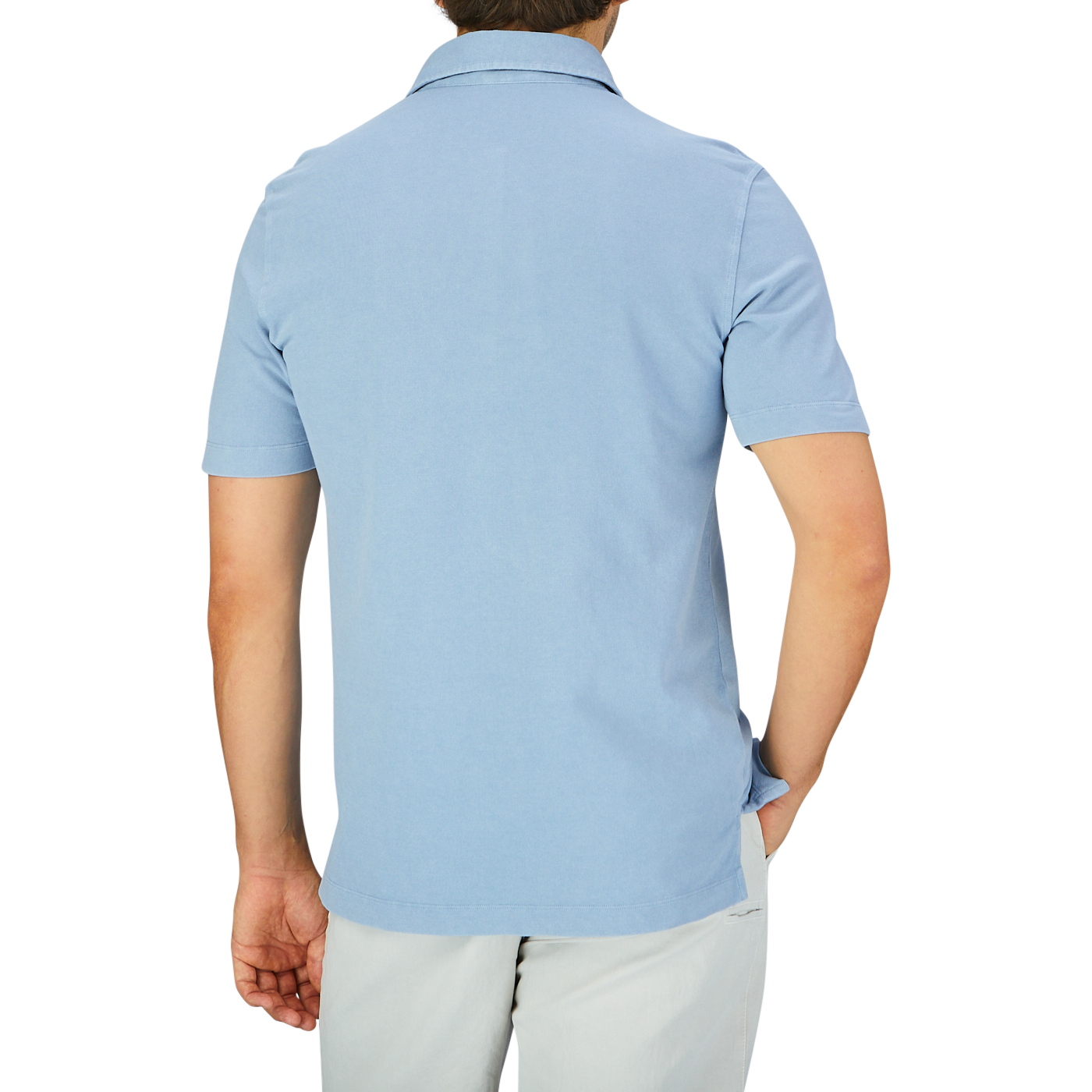 Rear view of a man wearing a light blue, short-sleeved Drumohr Sky Blue Cotton Piquet Polo Shirt and light-colored trousers against a plain background.