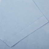 Close-up of a sky blue Drumohr cotton piquet polo shirt texture with a stitched seam, made in Italy.