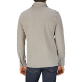 The man is wearing a grey Drumohr Taupe Beige Cotton Piquet LS polo shirt and jeans.