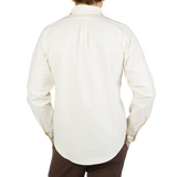 The back view of a man wearing a Far East Manufacturing Ecru Beige Cotton Oxford BD Regular Shirt.