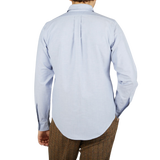 The back view of a man wearing a Far East Manufacturing Light Blue Cotton Oxford BD Regular Shirt and brown pants.