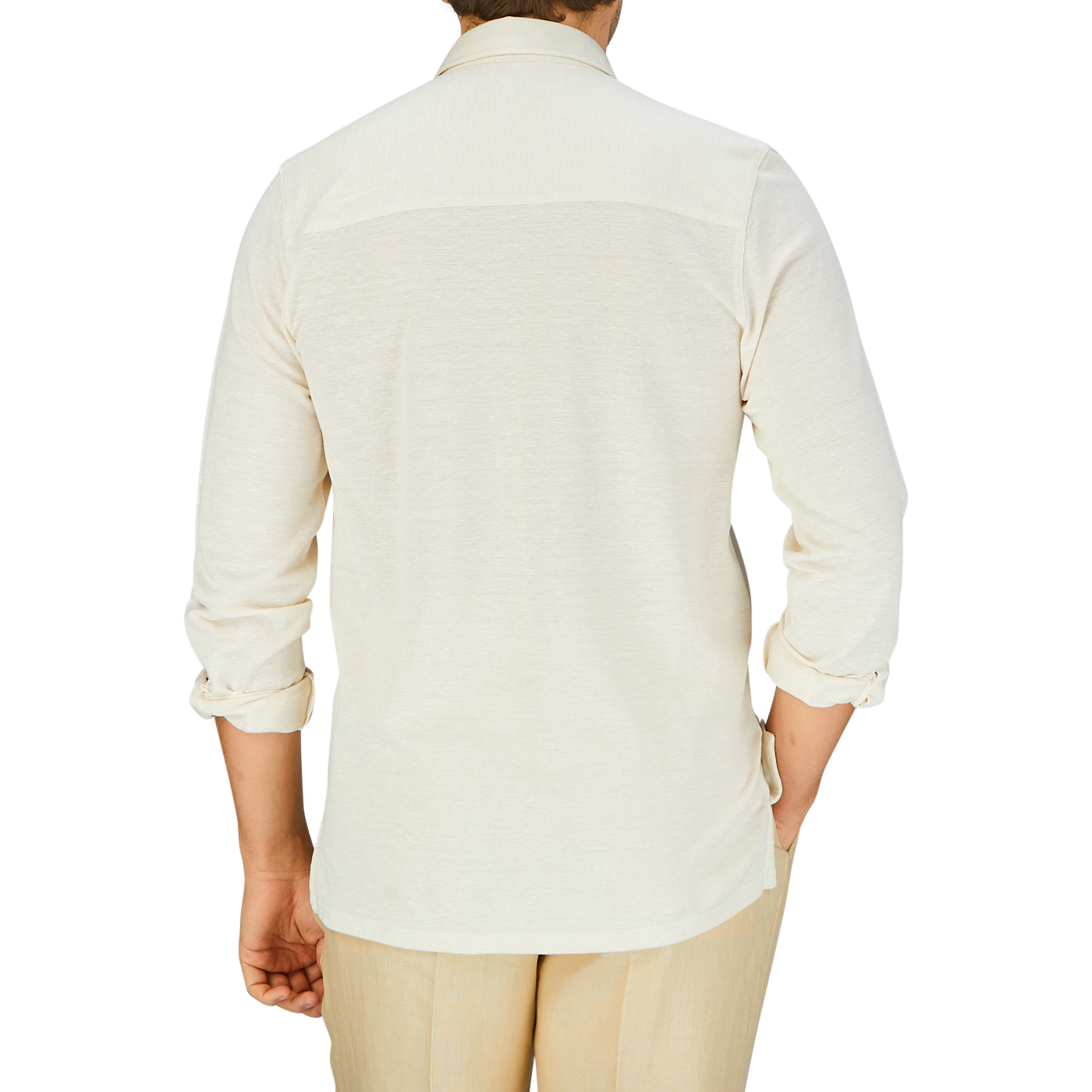 Rear view of a person wearing a Fedeli Ecru Cotton Linen Piquet Polo Shirt and beige trousers against a blue background.