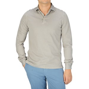 A man wearing a luxury Fedeli Taupe Beige Organic Cotton LS Polo Shirt and blue pants.