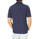The back view of a man wearing a Fedeli Washed Navy Cotton Pique Polo Shirt.