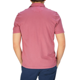 The back view of a man wearing a Fedeli Washed Raspberry Organic Cotton Polo Shirt.
