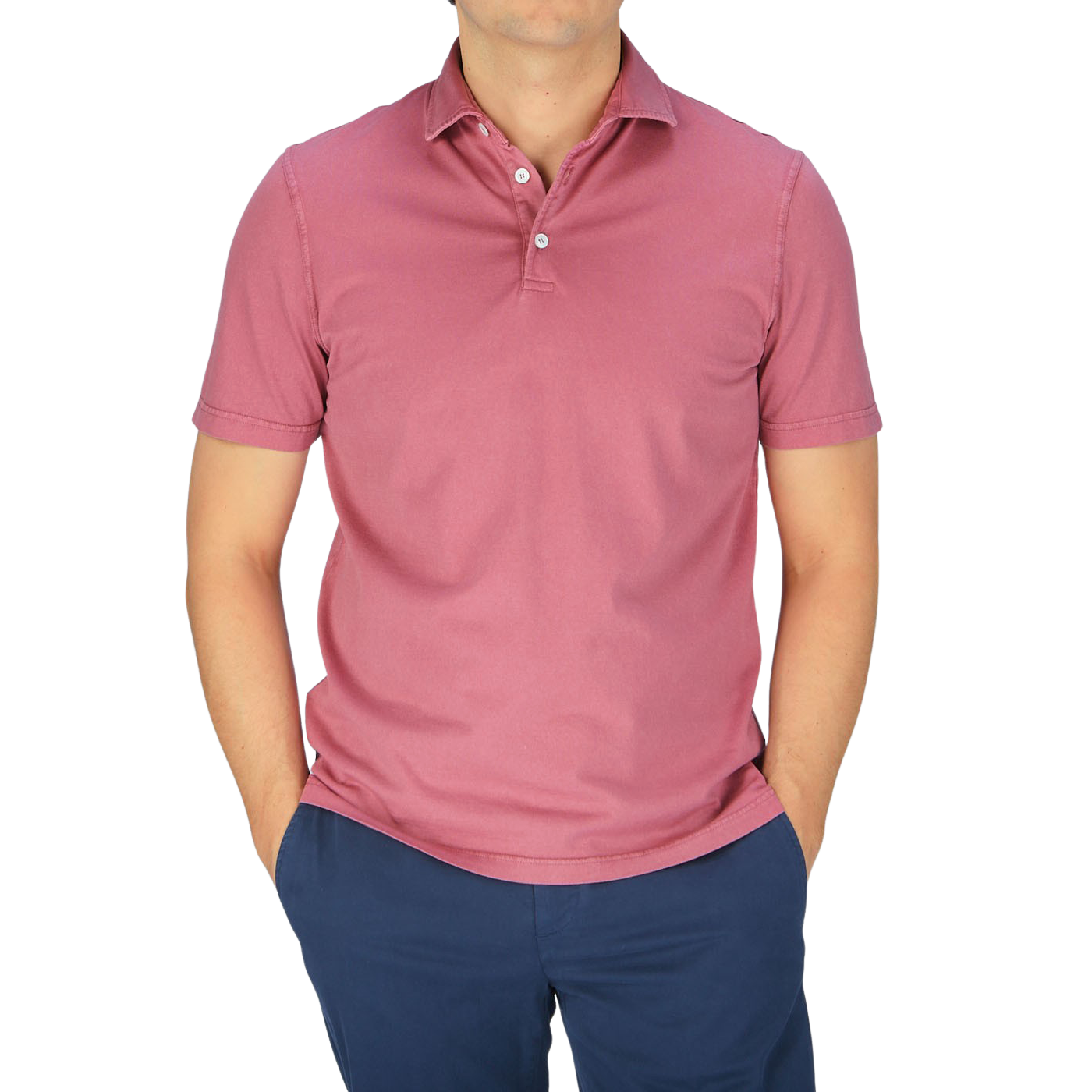 A man wearing a Fedeli washed raspberry organic cotton polo shirt and blue pants.
