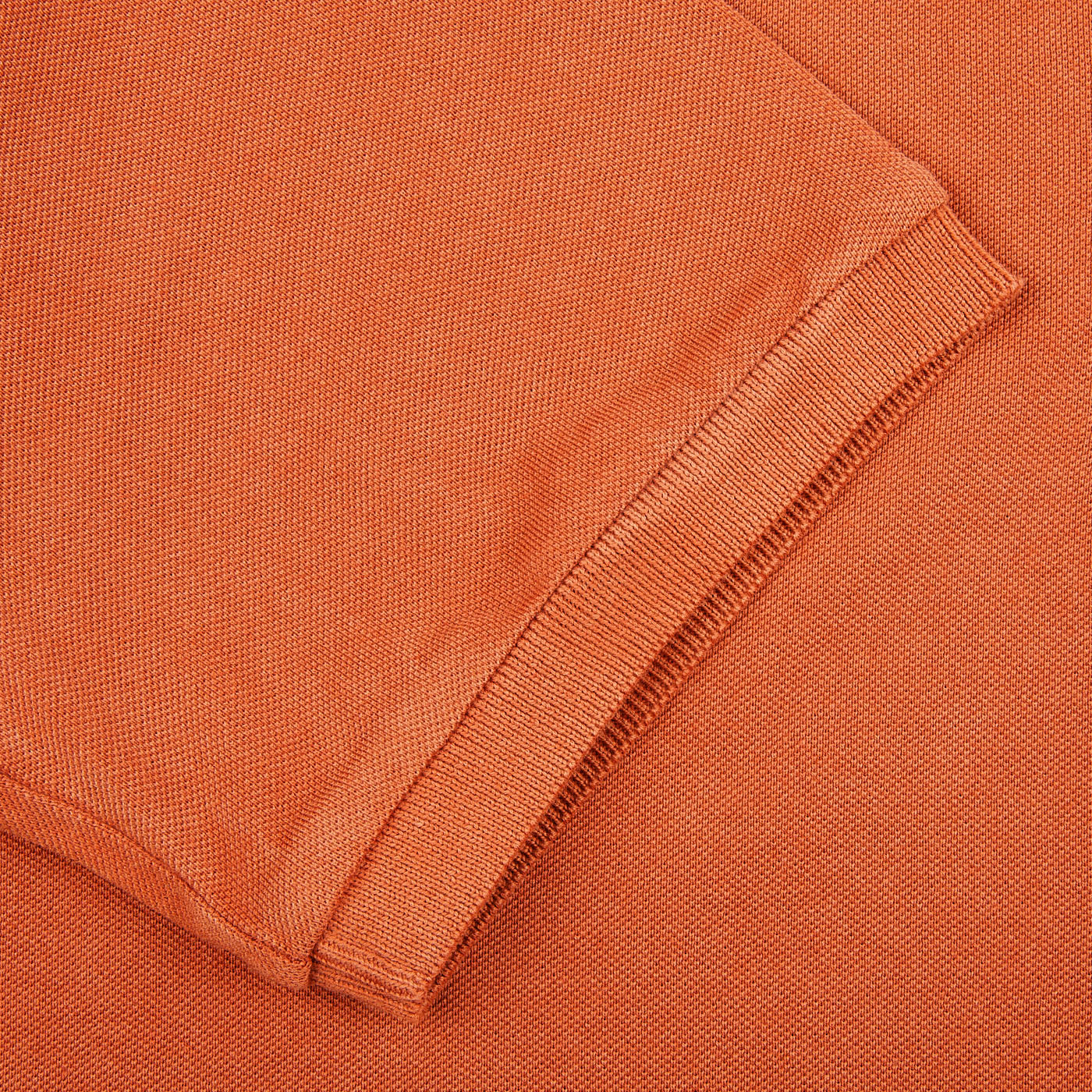A close up of a Fedeli Washed Rust Cotton Pique Polo Shirt.