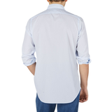 The back view of a man wearing a Finamore Washed Light Blue Striped Cotton Shirt from Naples.