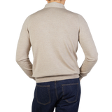 The back view of a man wearing a Gran Sasso Light Beige Merino Wool One-Piece Collar Polo Shirt and jeans.