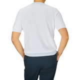 Rear view of a man wearing a Gran Sasso White Organic Cotton T-shirt and dark trousers, standing against a light gray background.