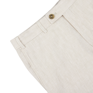 Close-up of Light Beige Washed Linen Regular Fit Chinos waistband with a button closure and belt loops on a white background by Hiltl.