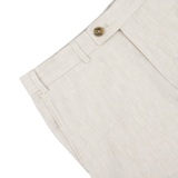 Close-up of Light Beige Washed Linen Regular Fit Chinos waistband with a button closure and belt loops on a white background by Hiltl.