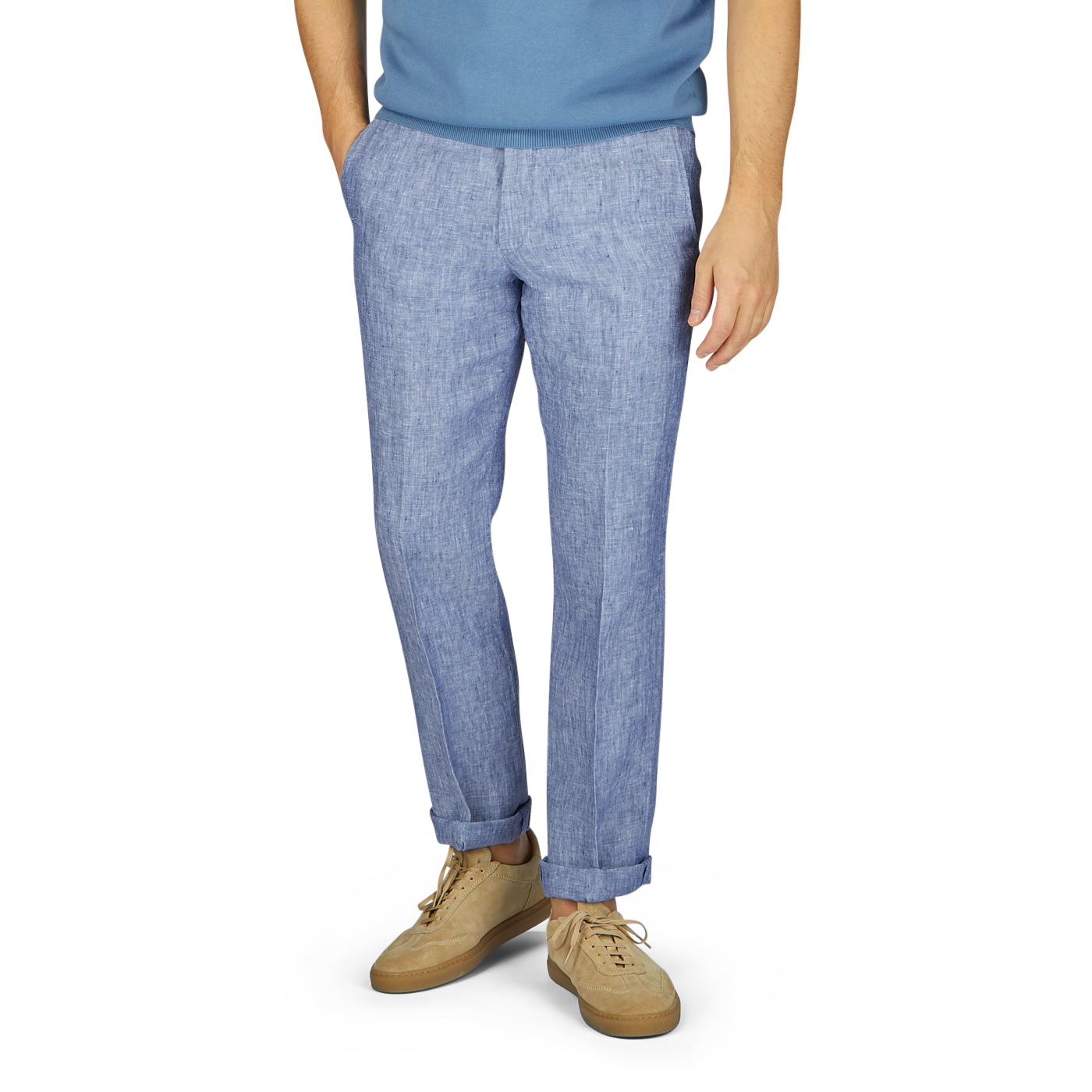A man wearing light blue washed linen regular fit chinos from Hiltl and beige sneakers stands against a gray backdrop, with only the lower half of his body visible from the waist down.
