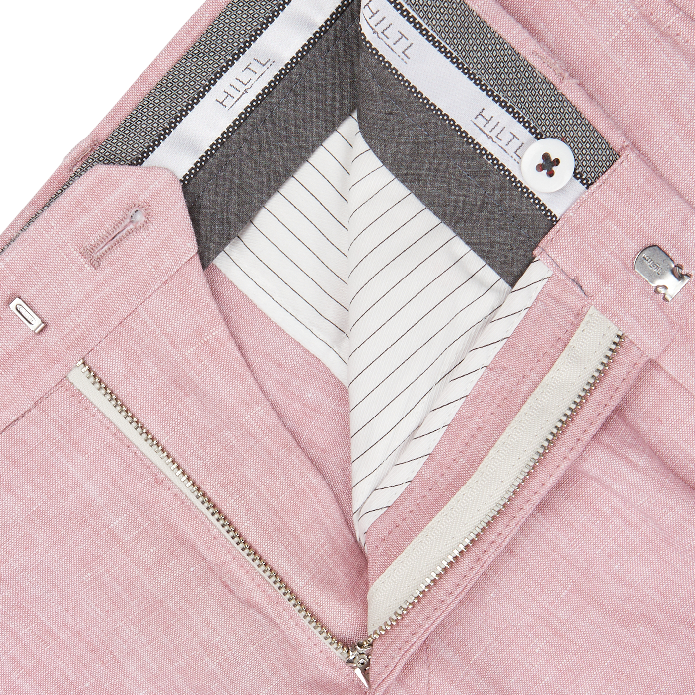 Close-up of a Light Pink Washed Linen Regular Fit Chinos from Hiltl with a zipper, featuring striped lining and designer labels.