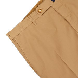 Close-up of a beige Incotex Royal Batavia chinos waistband with a button, displaying partial pocket and belt loops on a white background.