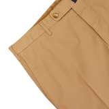 Close-up of a beige Incotex Royal Batavia chinos waistband with a button, displaying partial pocket and belt loops on a white background.
