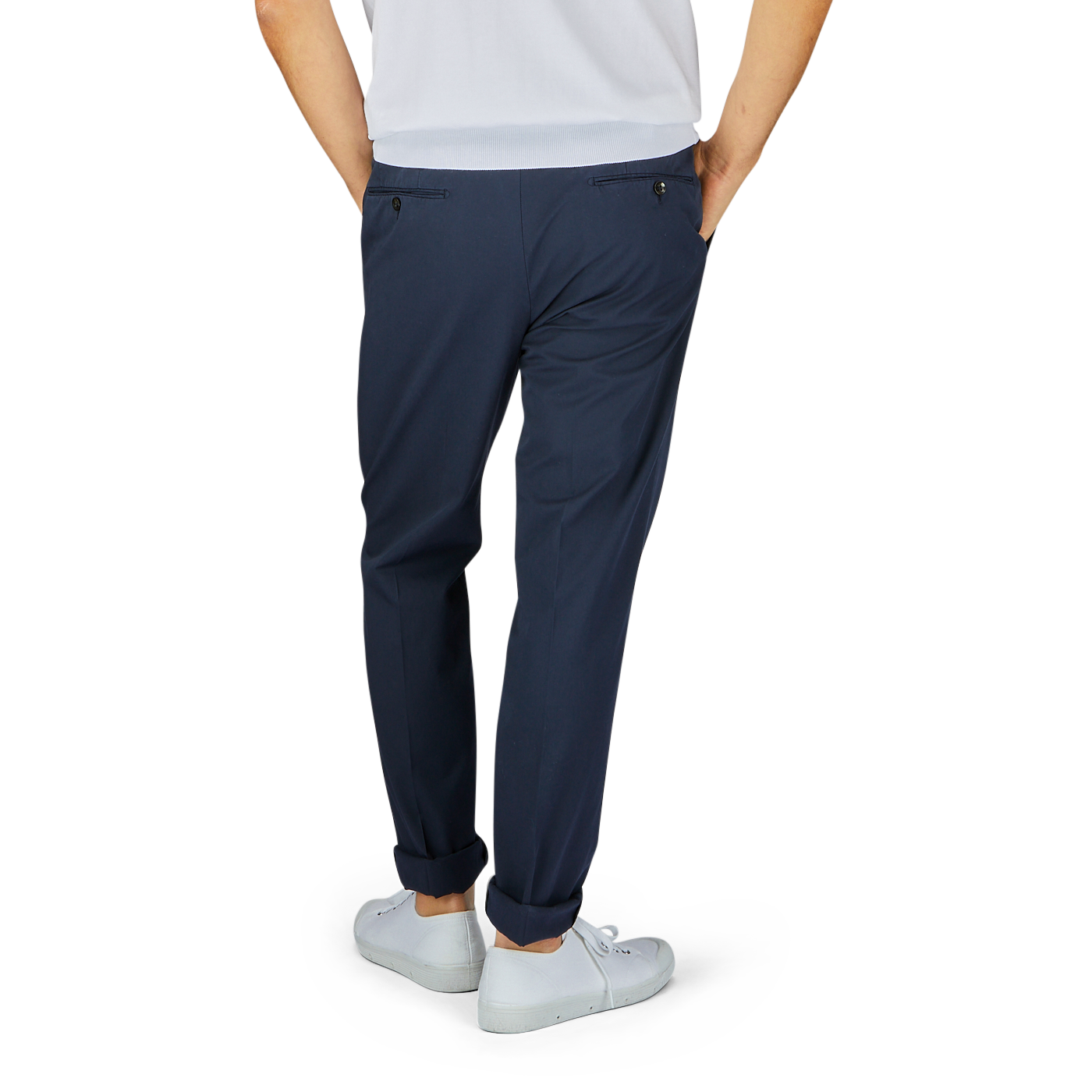 A person standing against a gray background showcasing Incotex navy blue cotton stretch regular fit chinos paired with white sneakers.