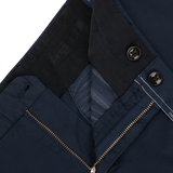 Close-up of a navy blue jacket with a zipper and button details, showing the inner lining and texture of the Incotex Navy Blue Cotton Stretch Regular Fit Chinos.