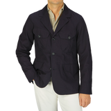 A man wearing a navy blue Ripstop cotton Bush Jacket from Manifattura Ceccarelli and white pants.