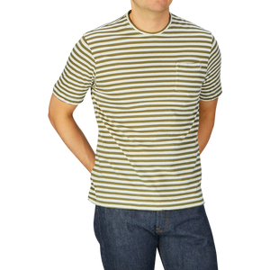 Man wearing a Massimo Alba olive green striped cotton linen t-shirt and jeans against a grey background.