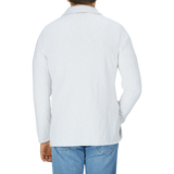 The back view of a man wearing a Cream White Cotton Mouline Swacket and jeans designed by Maurizio Baldassari.